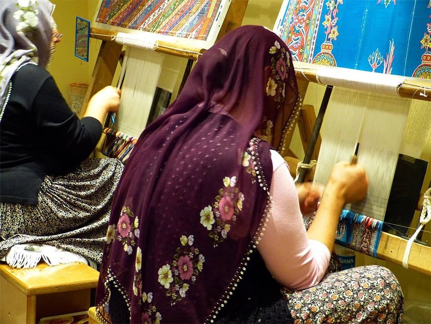Anatolian woman weaving carpet on a traditional wooden loom in Cappadocia